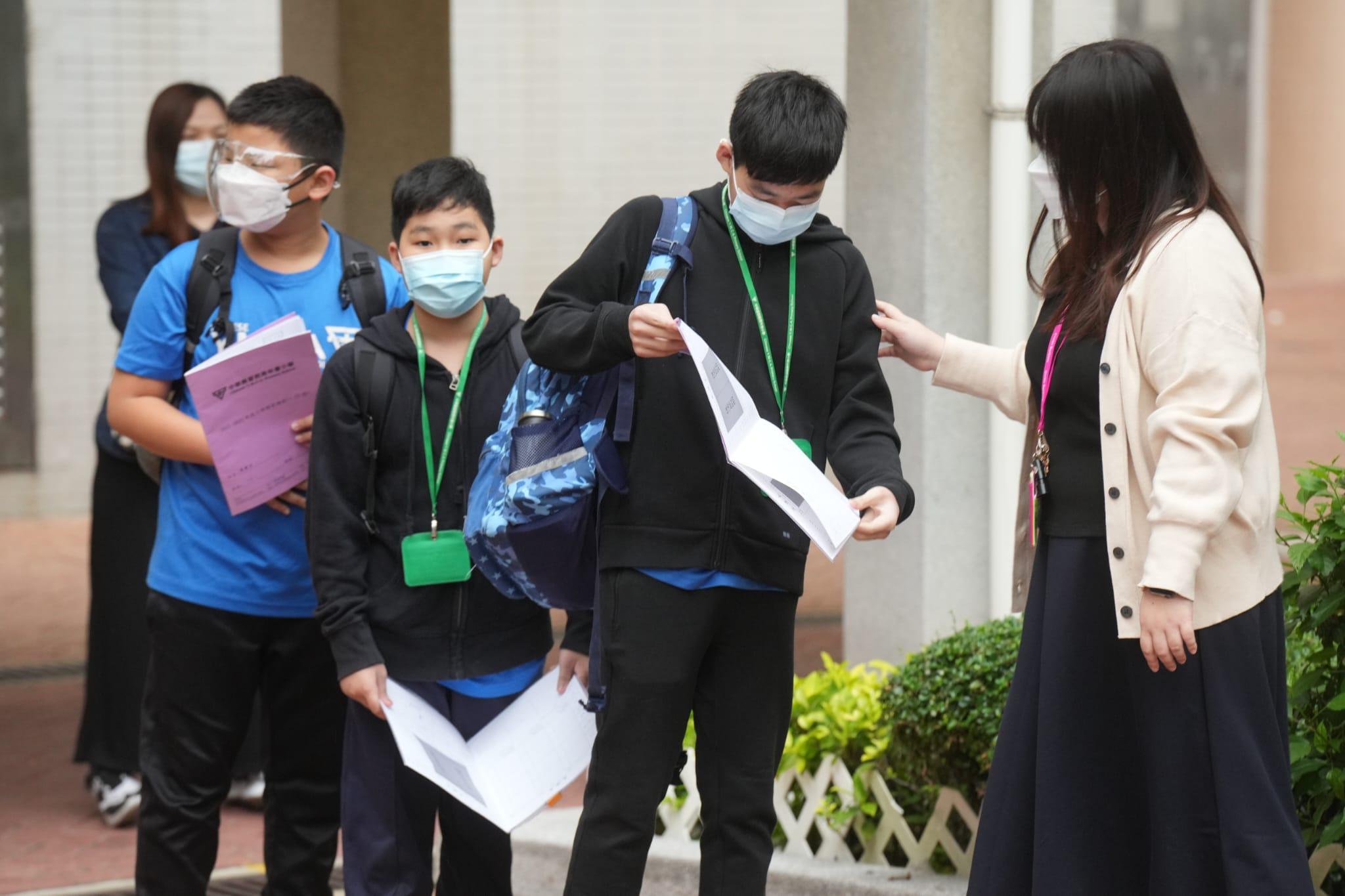 小學高年級今起率先復課,有學生入校園前需要讓老師檢查體溫及快速檢測結果記錄表。(陳奕釗攝)