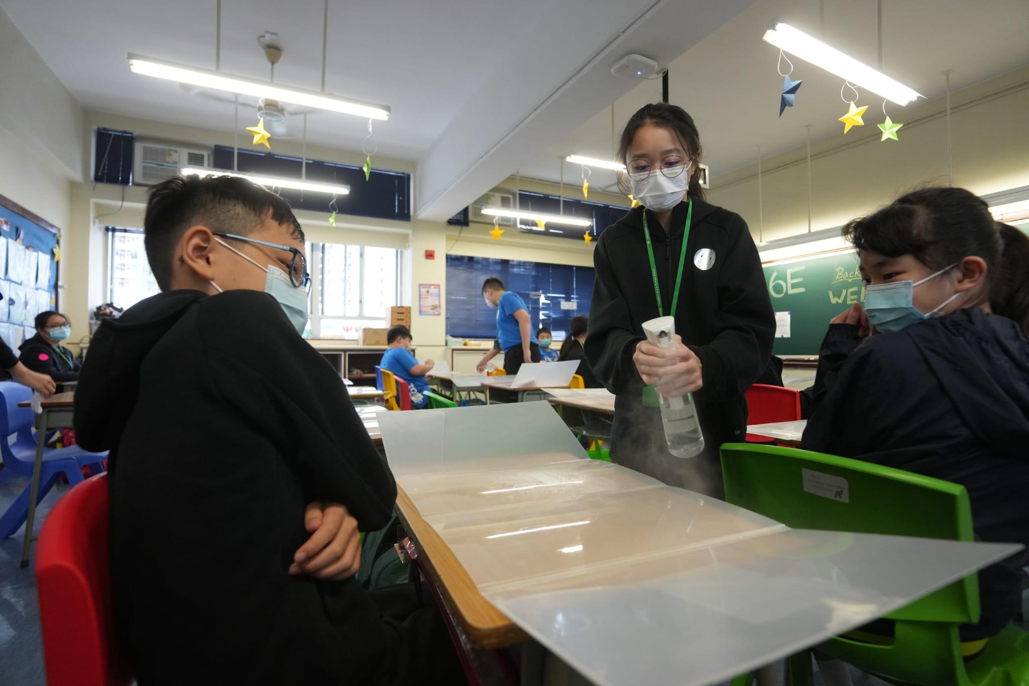 校方安排為每名學生的桌面消毒。(陳奕釗攝)