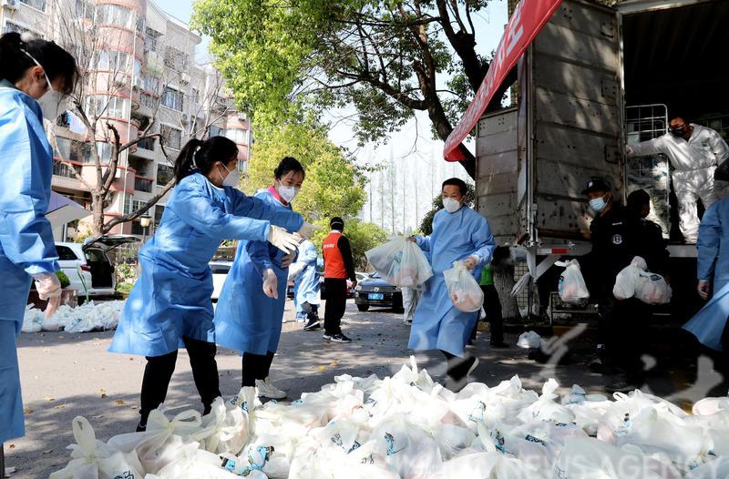上海的義工分派物資。(新華社圖)