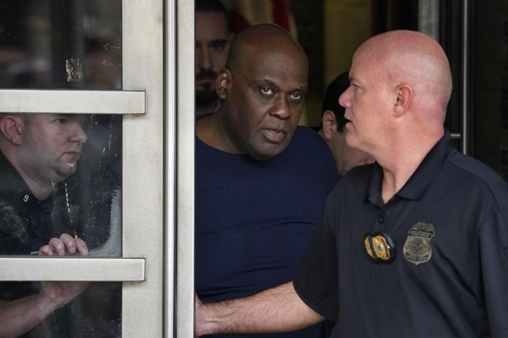 疑犯在警員押解下離開警局,將在周四提堂。(AP)