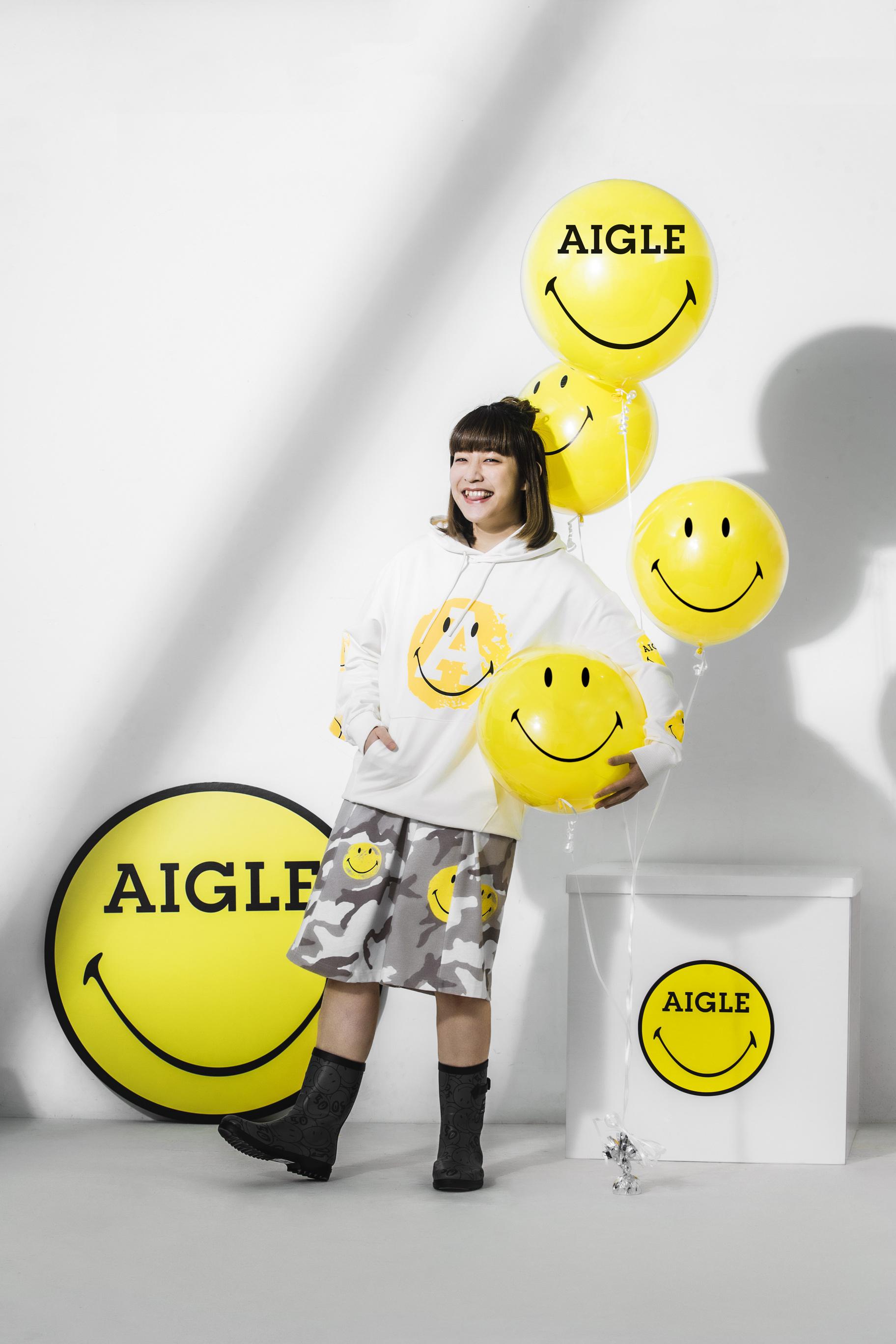 阿正身穿SMILEY笑臉的棉質連帽衛衣,配搭灰色迷彩印花與笑臉圖案的連衣裙,兼備女性化與型格元素,為造型更添層次感;另外配上AIGLE x SMILEY限量法國手工橡膠靴,舒適輕巧。