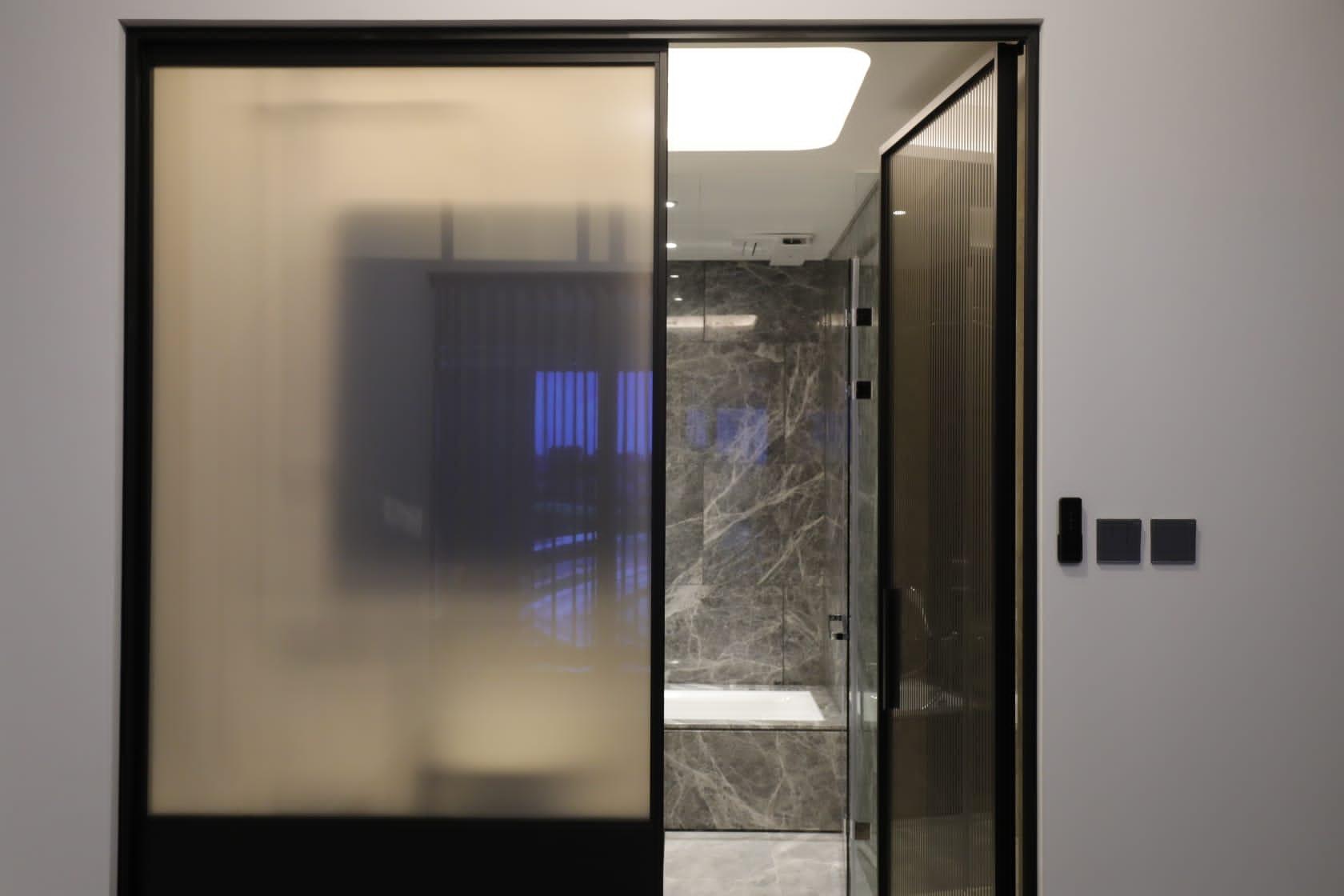 主人房套房的浴室以智能通電玻璃窗作分隔,玻璃窗配備遙控裝置,可按需要來霧化玻璃,增加私隱度。(林俊源攝)