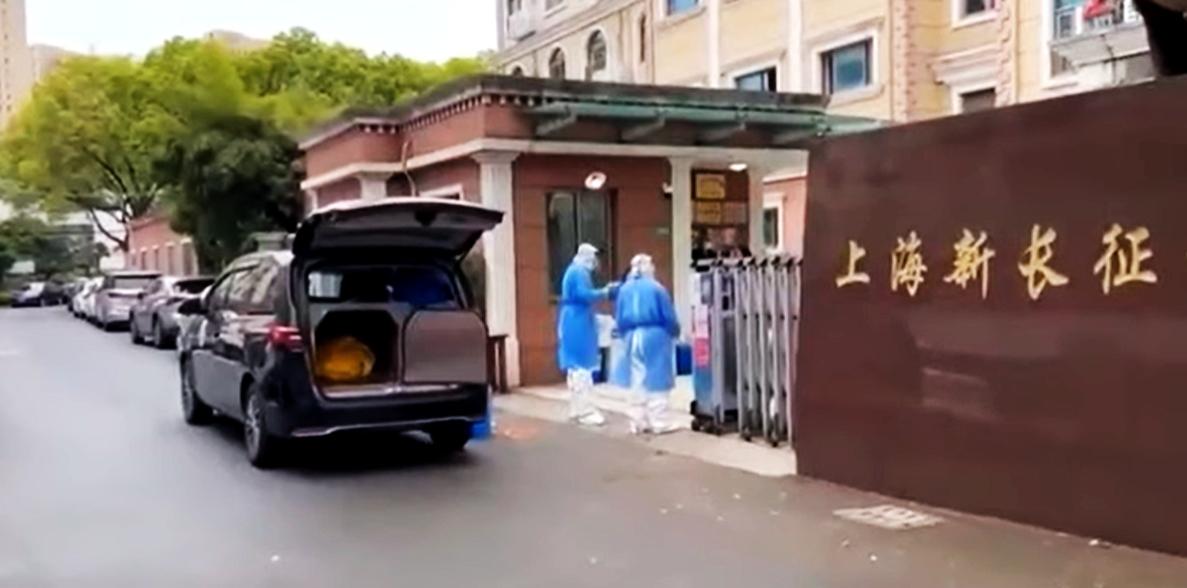 上海一間老人院將未死的老人裝入屍袋送上殯儀館車輛,殯儀館2名職員發現問題後,向老人院職員質問「你們確認這個人死了嗎」。(互聯網)