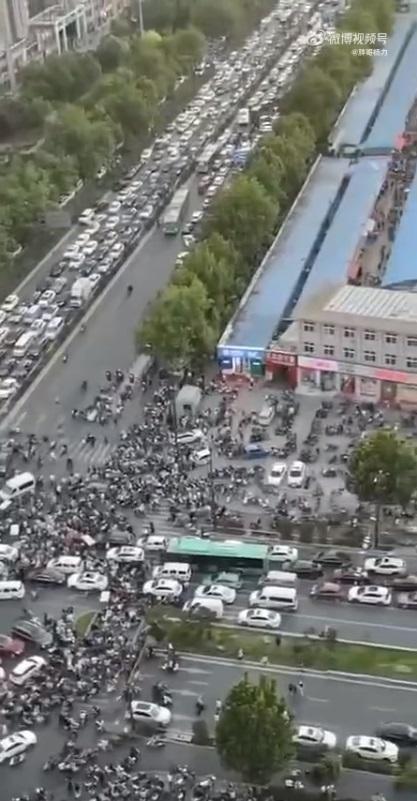 河南鄭州宣布封城一周,當地許多市民駕車搶購物資,造成超市外的路口擁堵不堪。(網片截圖)