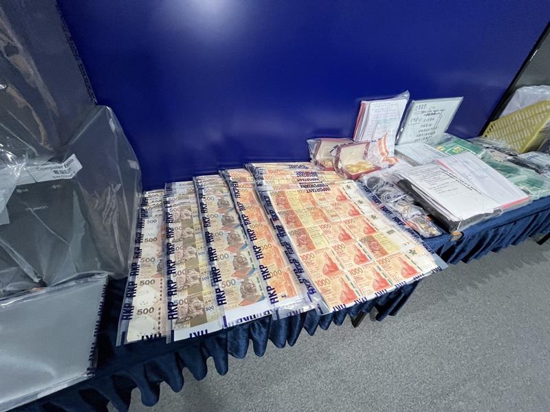 警方展示在行動中檢獲的現金。