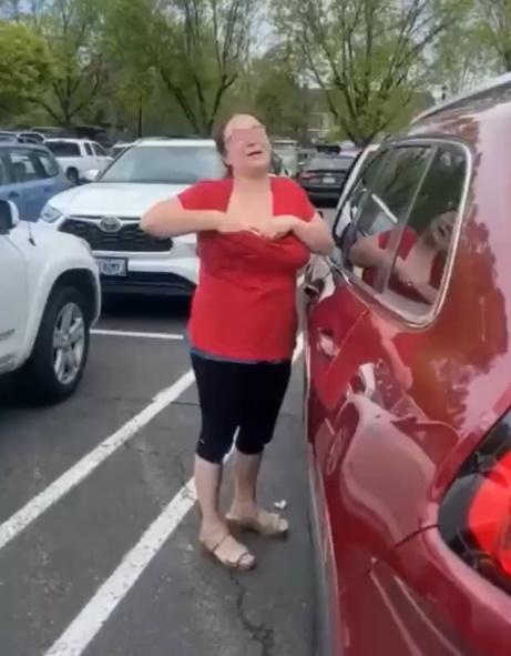 片中身穿紅色V領T恤的婦人則不斷稱「不是,這是母乳,不是公開猥褻」,同時伸入到領口。(Twitter)