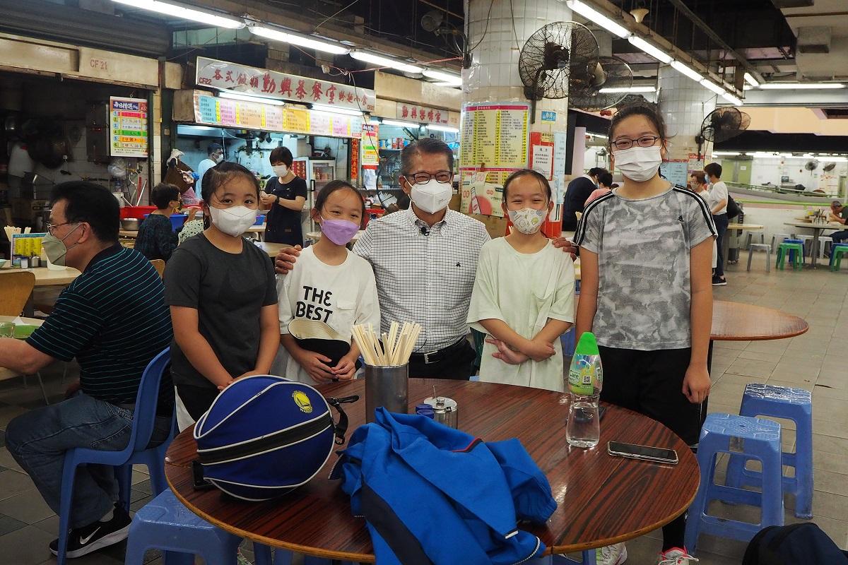 陳茂波(右三)昨到長沙灣一間熟食中心食早餐,其間與市民合照。(網誌圖片)