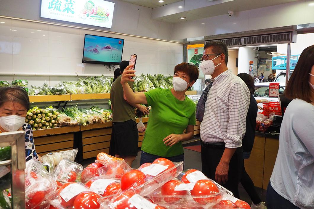 陳茂波(右)昨到長沙灣一間街市買餸,其間與市民合影。(網誌圖片)