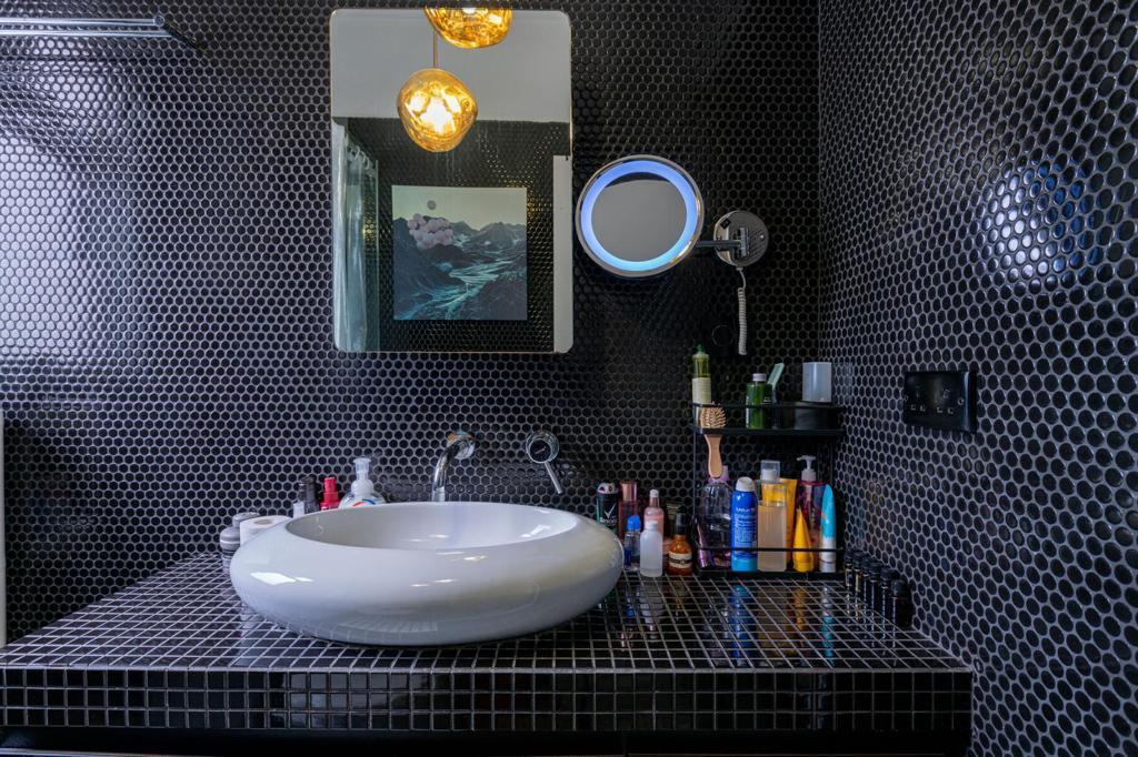 浴室牆身以黑色紙皮石設計,配上復古金屬燈具,設計極具個性。