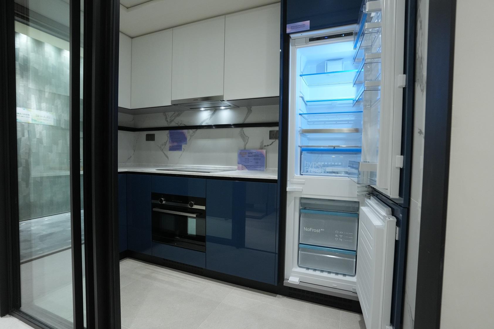 廚房以白色及深藍色為主,設有廚櫃及基本家電。