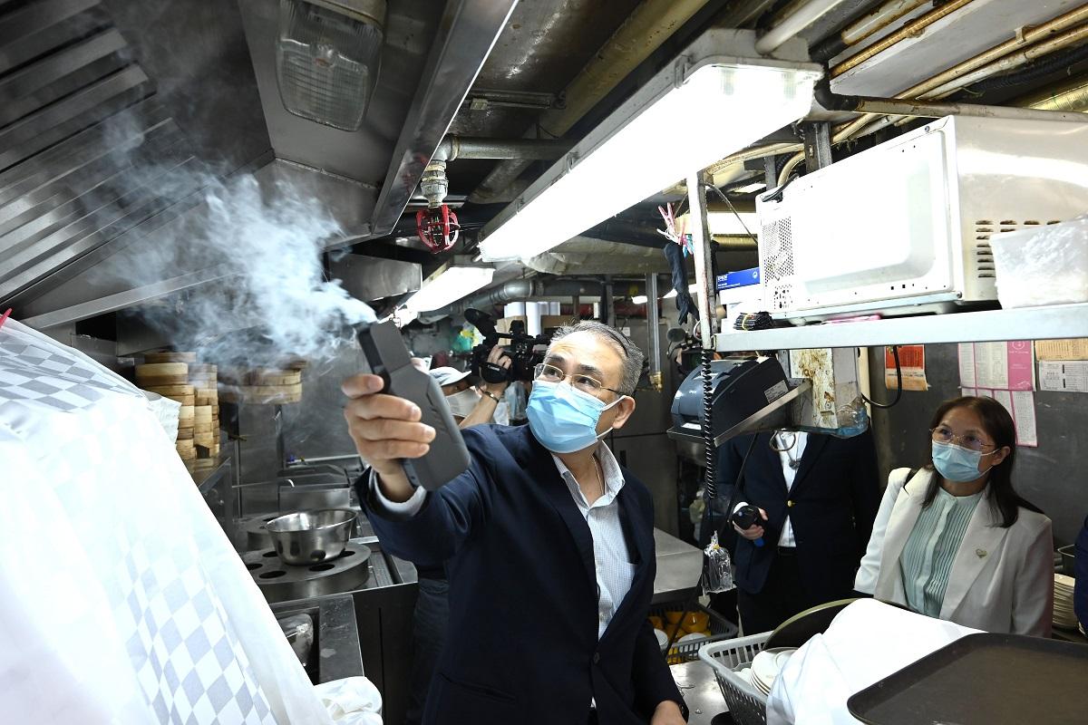 源柏樑(左)用煙霧測試通風口抽氣情況。(政府新聞處)