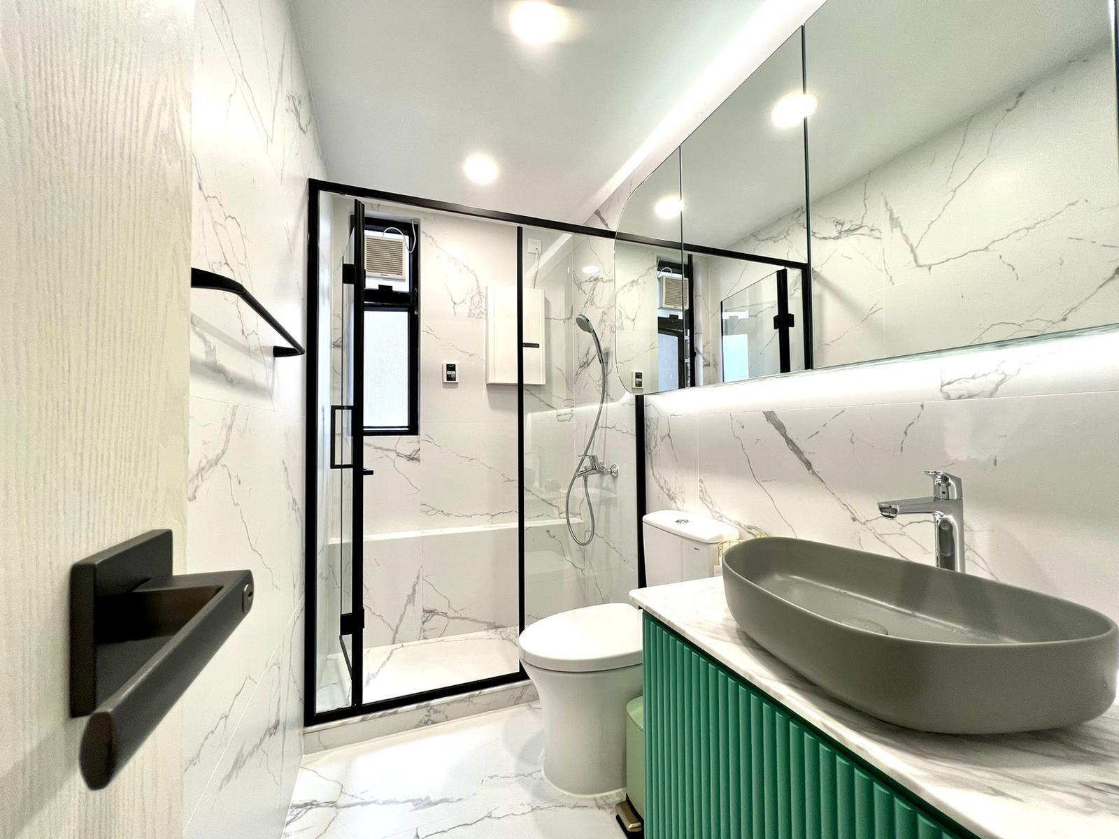 浴室設計猶如精品酒店的格局,透明玻璃黑框企缸,型格實用,配上圓角鏡櫃、不規則洗手盆和立體條紋廁櫃,有型得來用料亦佳,相當討好。