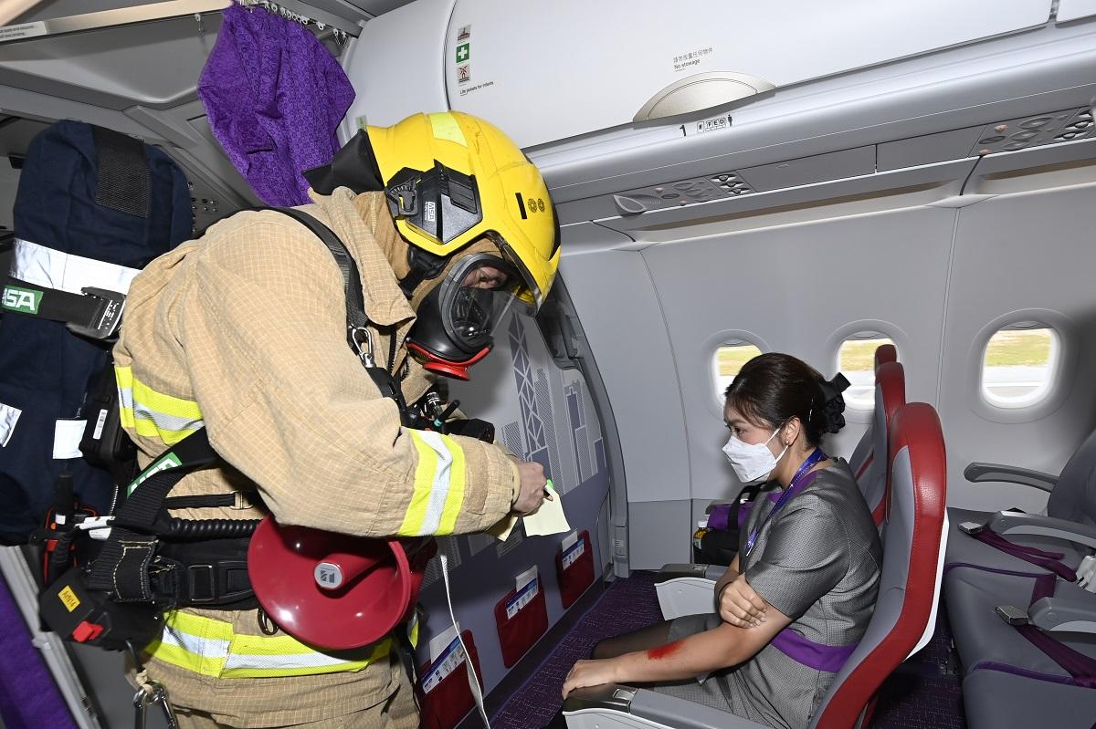 有消防員登上客機救治受傷機艙服務員。(政府新聞處)