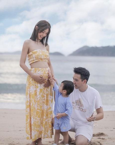 囝囝好奇地輕撫倪晨曦微隆的肚子。