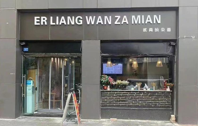 為了迎接大運會已改的招牌,將拼音變成大字,漢字變成小字,驟眼看很難發現這是招牌。(互聯網)