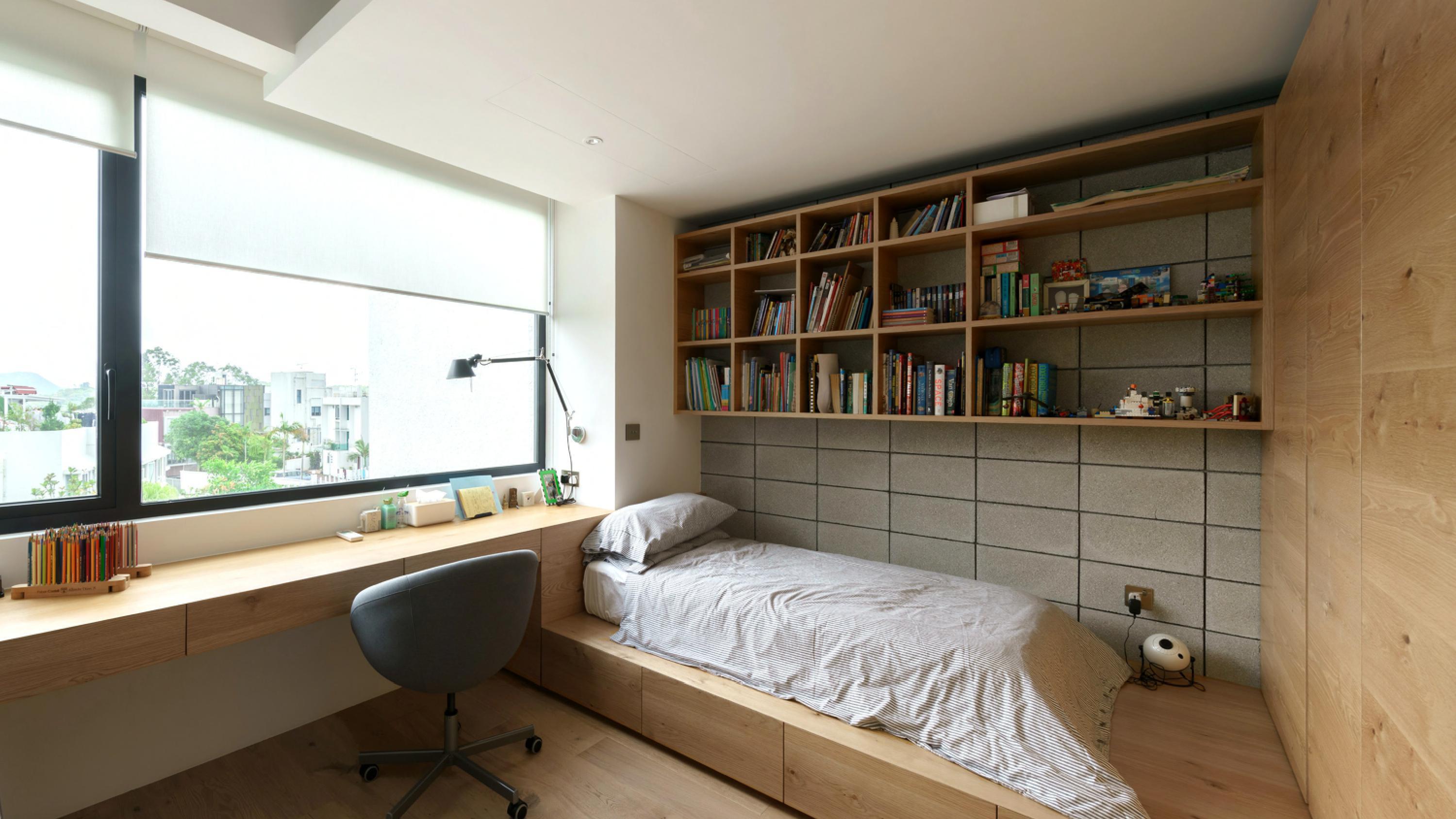 其中一個睡房採地台設計,闊大的窗戶帶來充沛光線,也是工作或學習的理想房間。