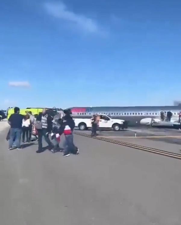 機尾起火部分有火焰及燶煙冒出,乘客從客機離開。(Twitter)