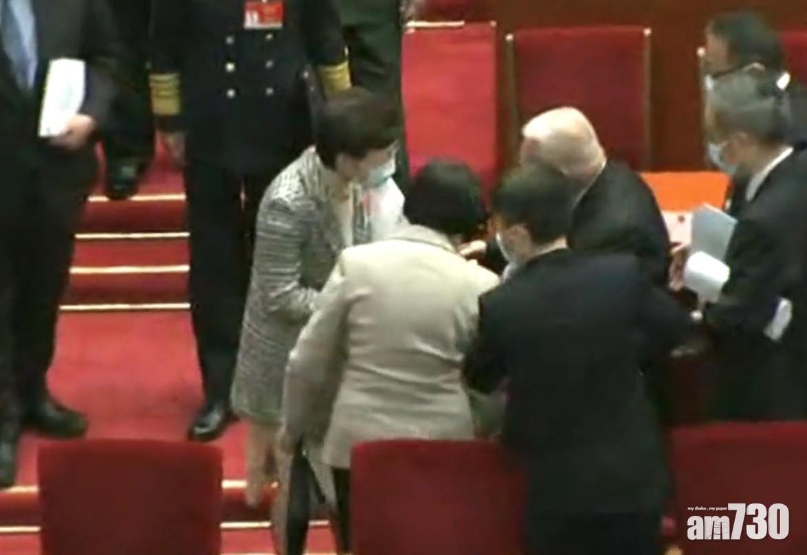 去年3月全國人大會議開幕禮中,董建華離場時被影到在台上跌倒,需要旁人上前扶起。(資料圖片)