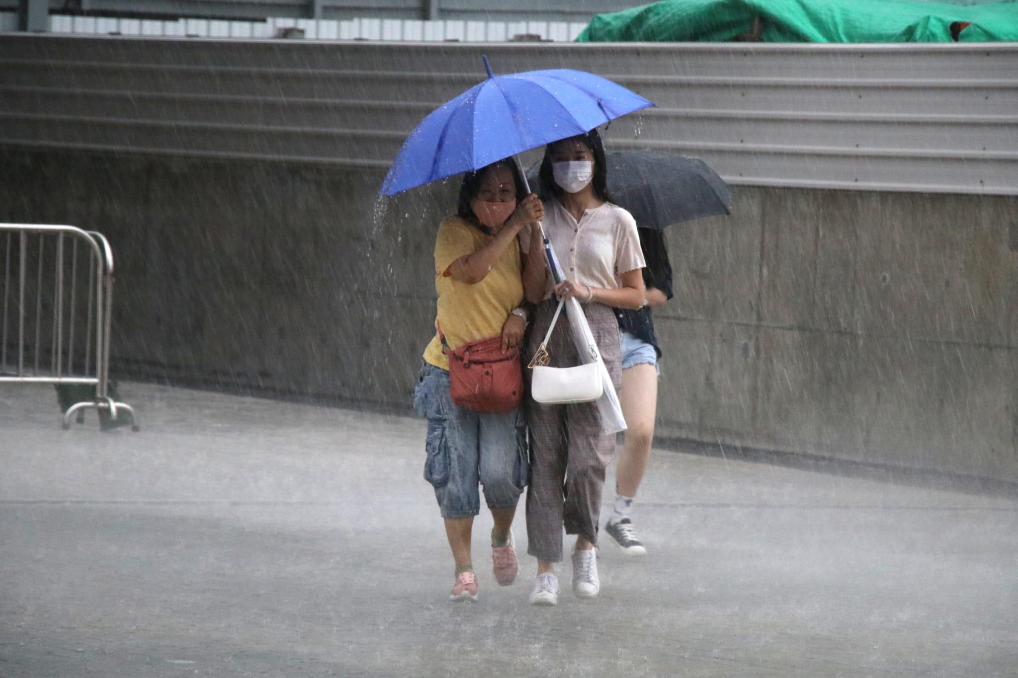 市民在大雨中步行。(林俊源攝)