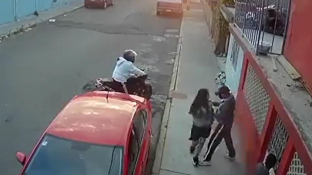 女友故作鎮定繼續前行,直到搶匪抓住她的手。(Twitter)