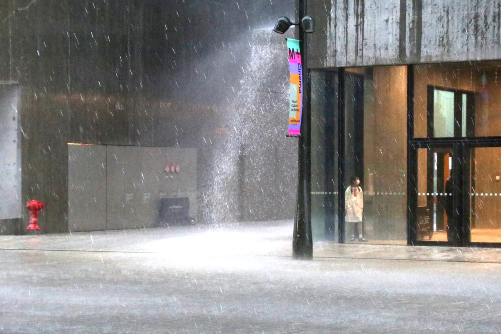 有市民在建築物內避雨。(林俊源攝)