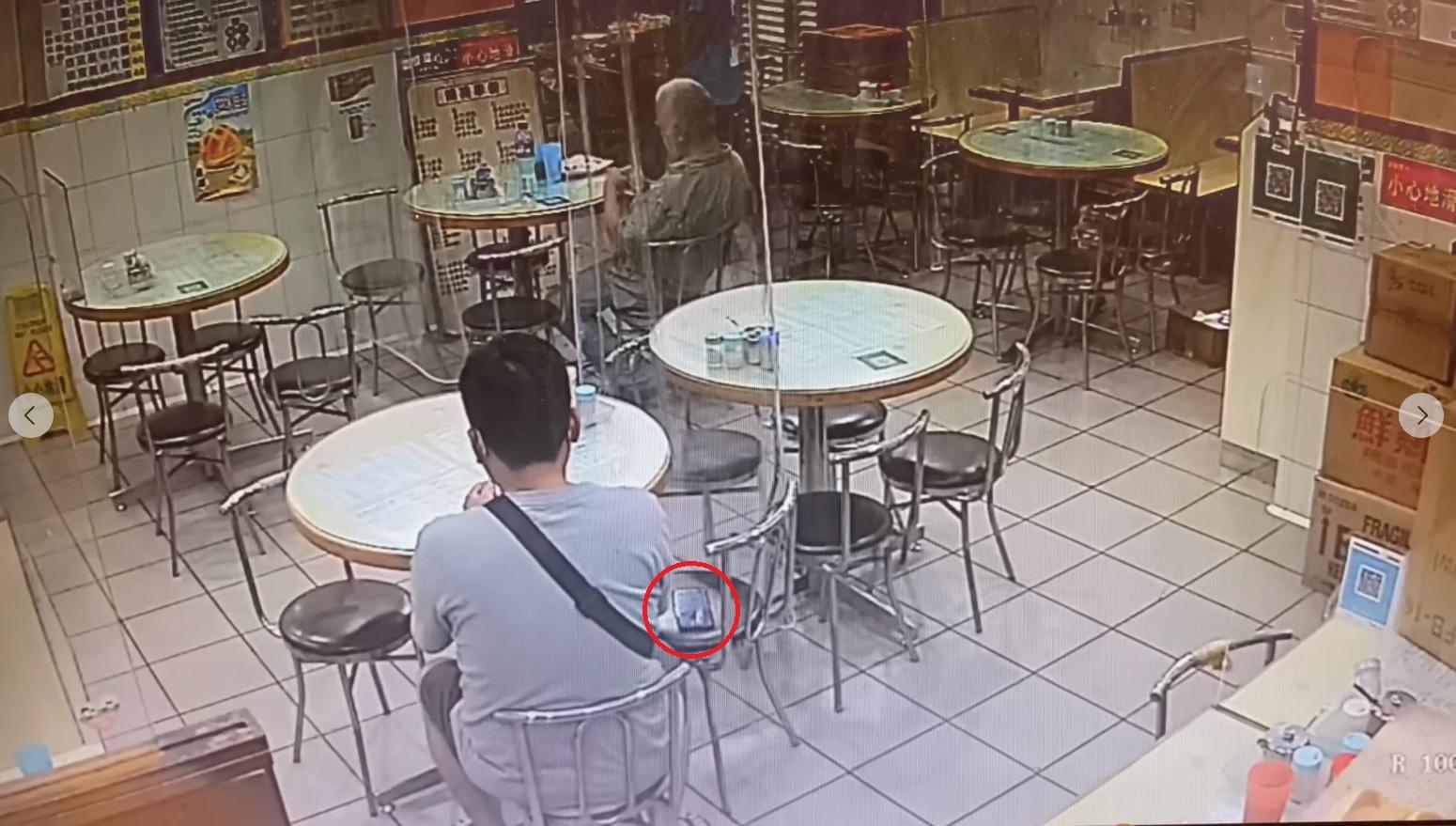 灰衫男子在手機旁邊坐下