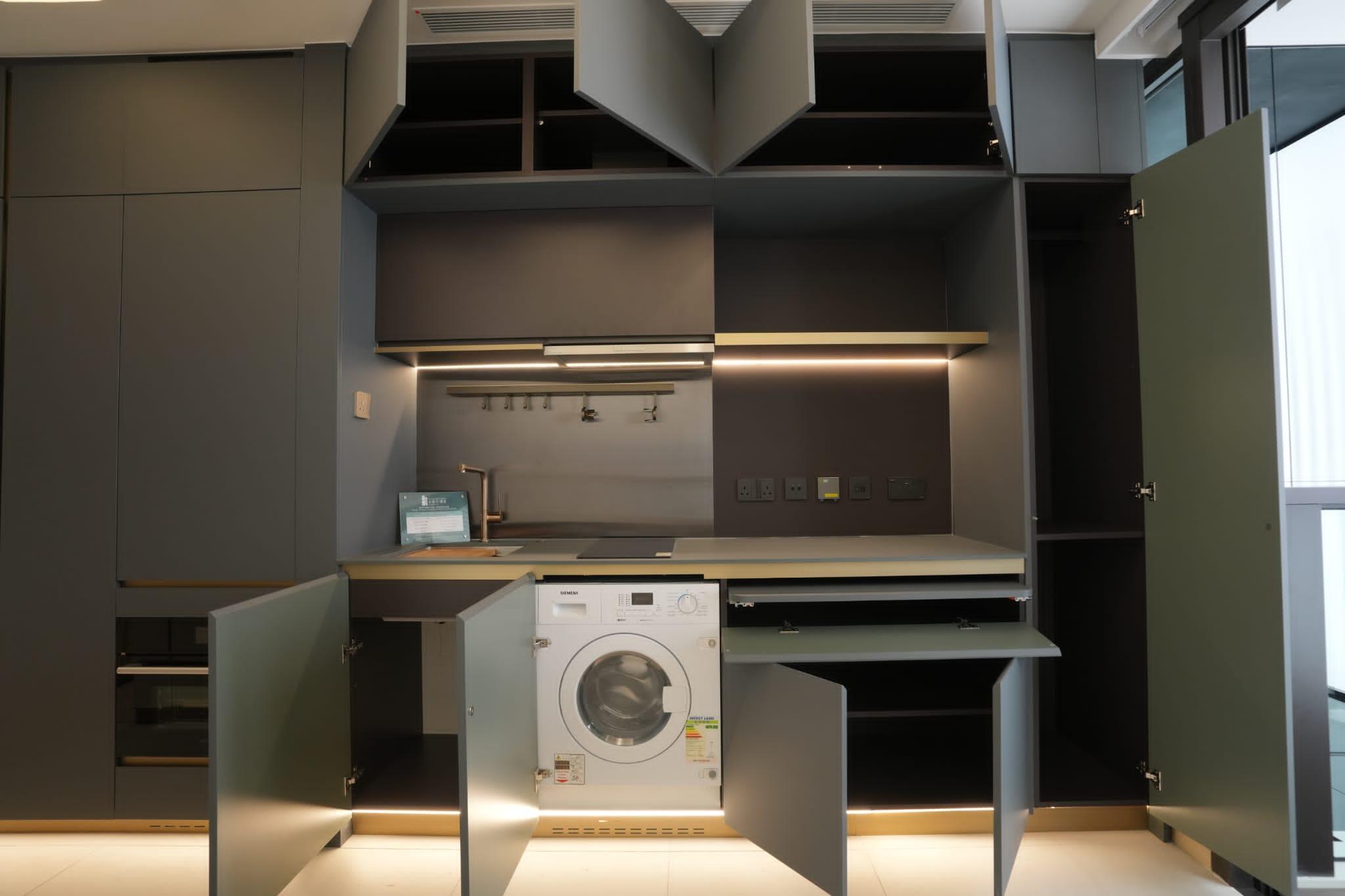 大型組合櫃與開放式廚房以一體化呈現,提供掛衣空間、衣物收納、儲物間隔、電視櫃、推拉式枱面,以及廚櫃、各種下廚家具和家電,一體式的設計貼心又實用。(陳奕釗攝)