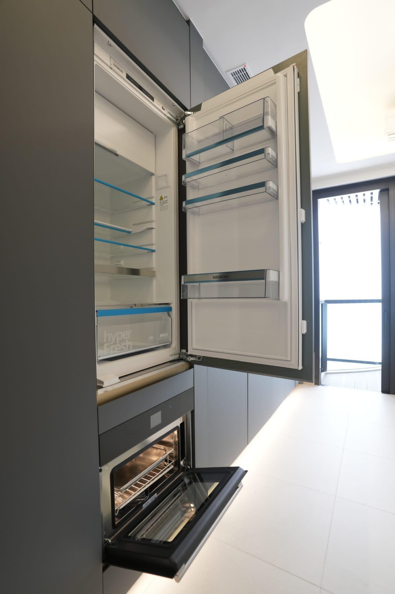 大型組合櫃與開放式廚房以一體化呈現,提供掛衣空間、衣物收納、儲物間隔、電視櫃、推拉式枱面,以及廚櫃、各種下廚家具和家電,一體式的設計貼心又實用。(陳奕釗攝)