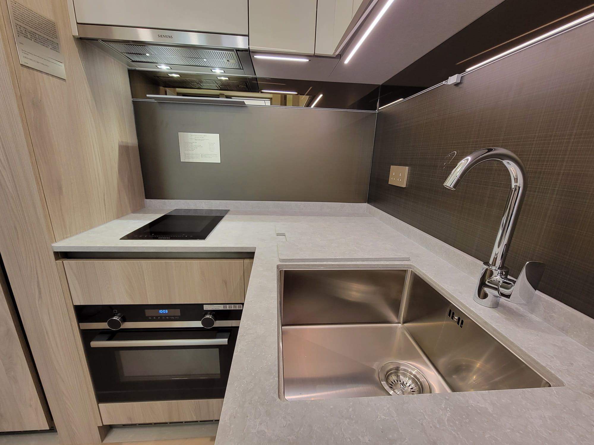 開放式設計的曲尺形廚房,各式下廚家電和配套齊備。(鍾式明攝)