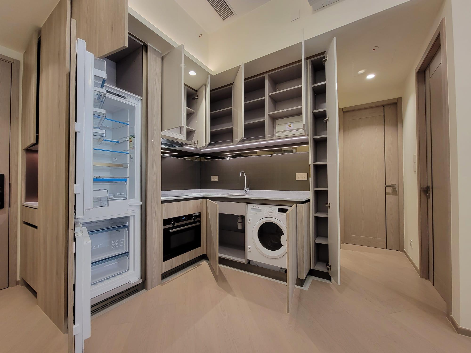 開放式設計的曲尺形廚房,各式下廚家電和配套齊備。(鍾式明攝)