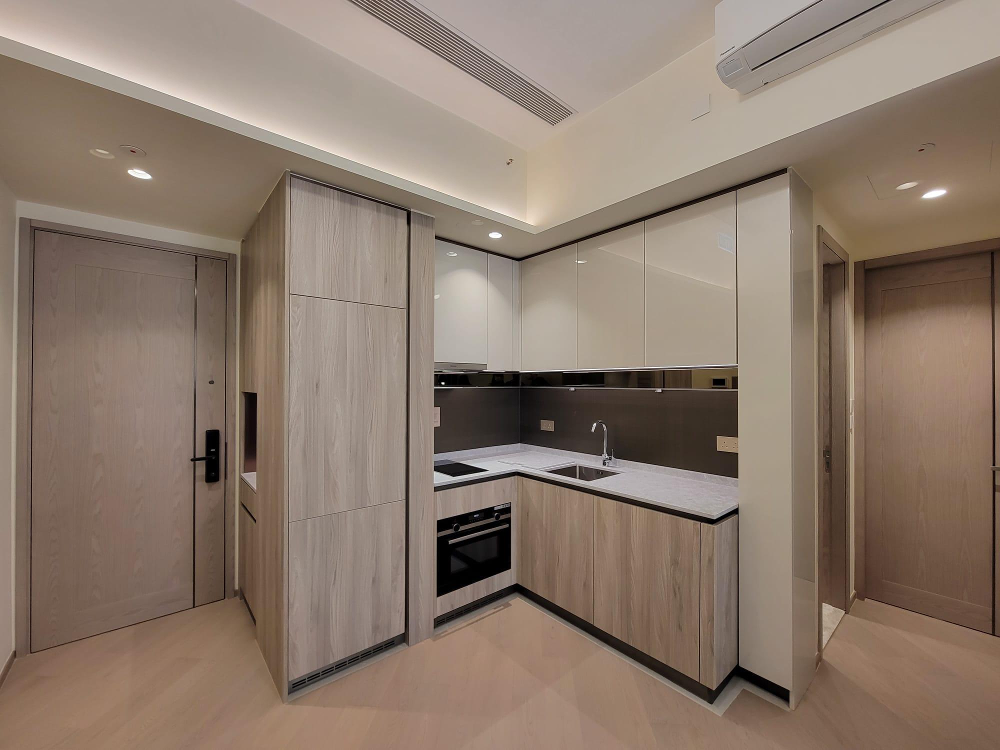 開放式設計的曲尺形廚房,各式下廚家電和配套齊備。(鍾式明攝)