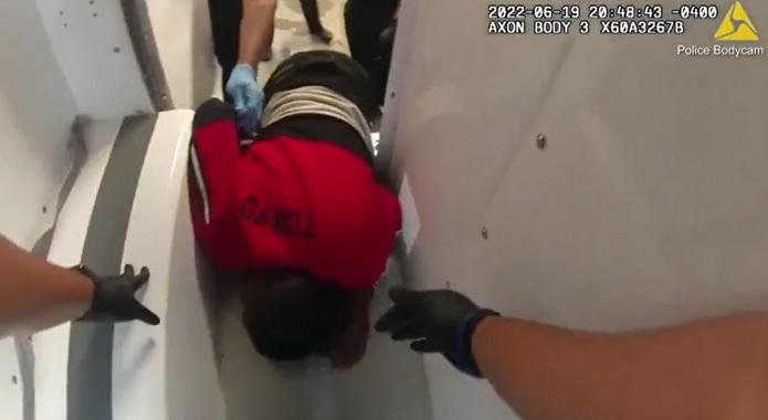 警員抓著考克斯雙腳,將他拉出警車。(互聯網)