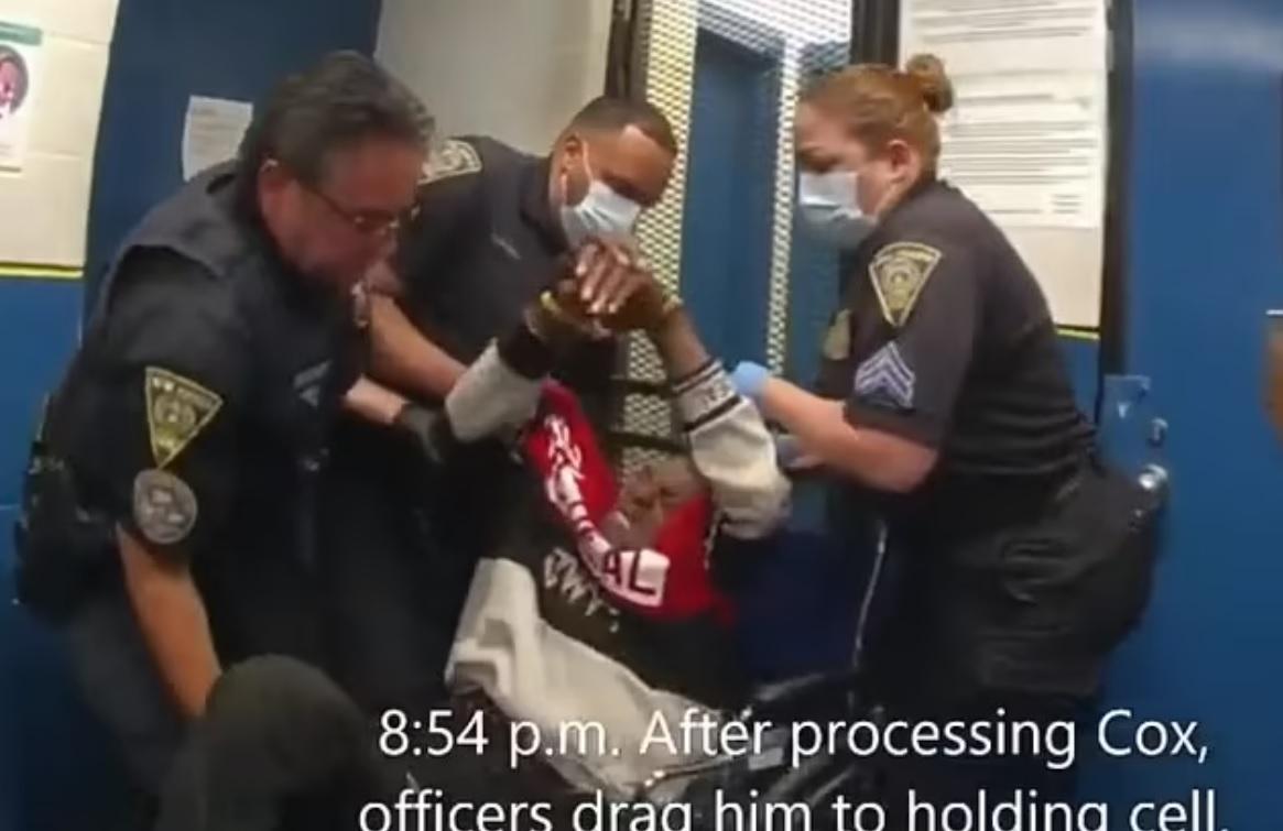 考克斯被警員拉進警署,面露痛苦表情。(互聯網)