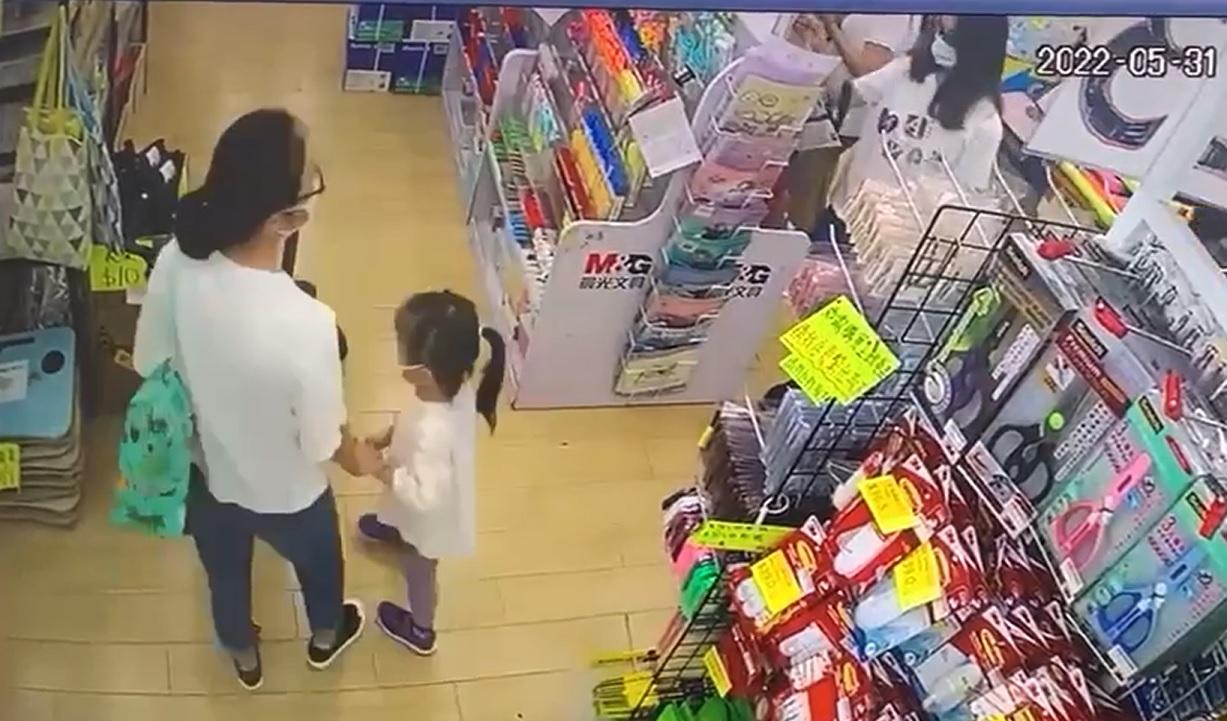 片段顯示身穿白亡衣的媽媽帶著一名女童。