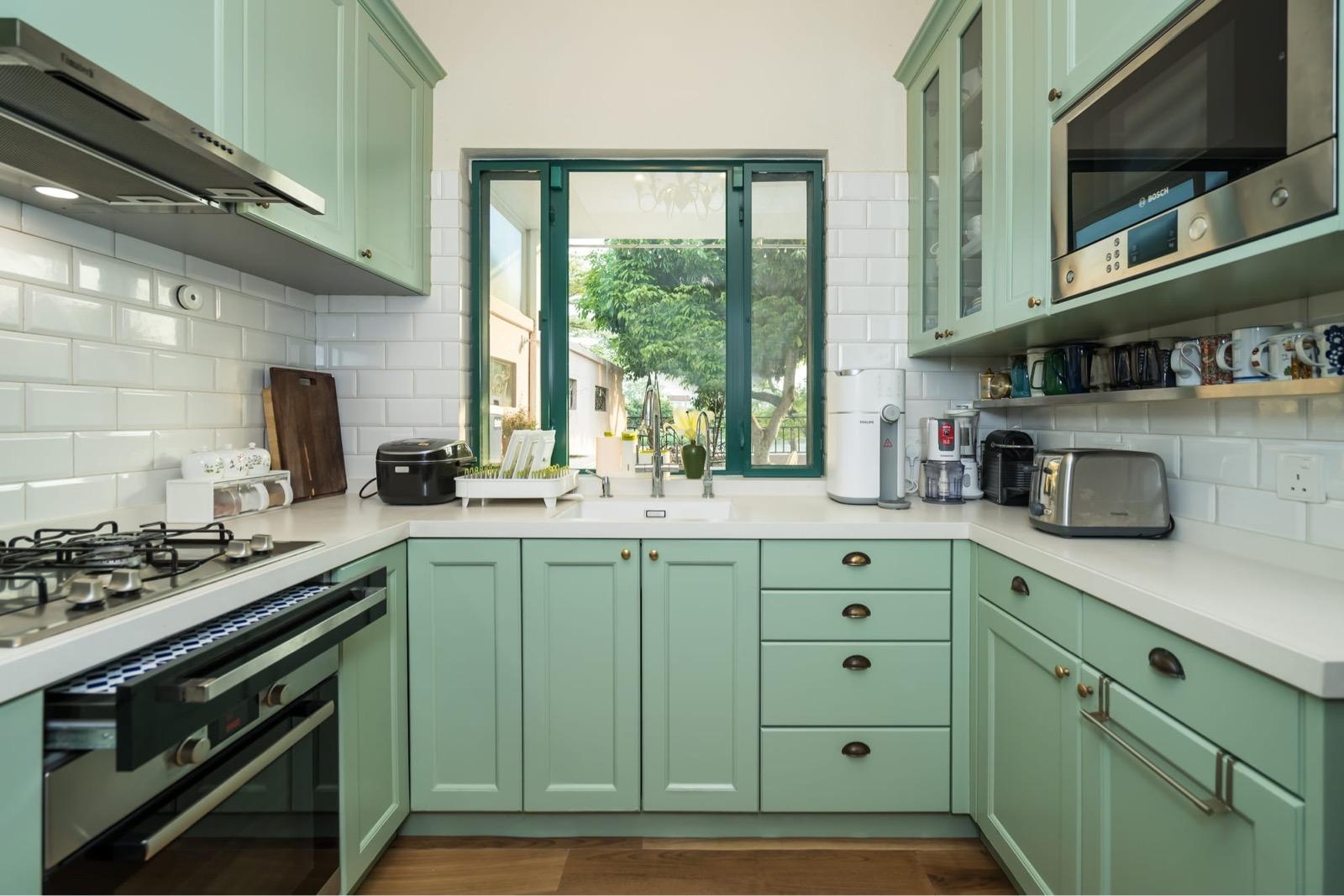 廚房以滿有氣質的莫迪蘭綠廚櫃,配上白色半磚牆、深綠色窗框,每個空間細節都花過心思配搭。