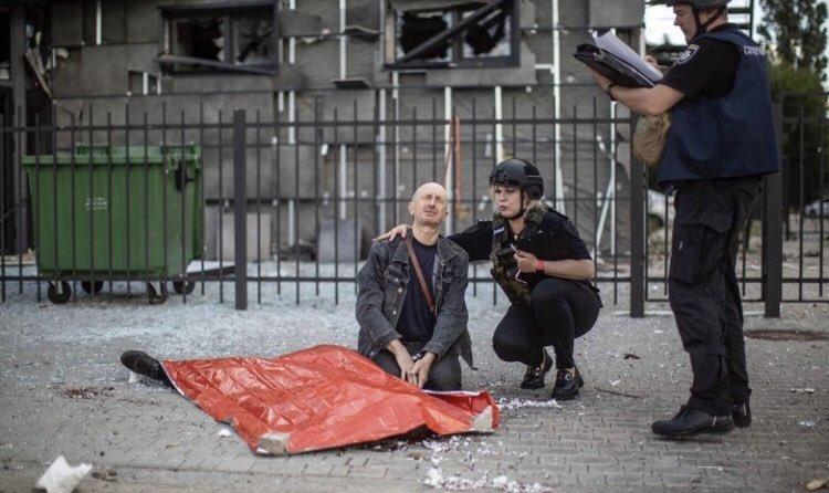 Dmytro Kubata的父親跪坐在旁邊,將兒子的手放在自己的膝頭上握著禱告哀悼。(Twitter)