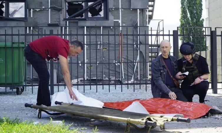 Dmytro Kubata的父親跪坐在旁邊,將兒子的手放在自己的膝頭上握著禱告哀悼。(Twitter)