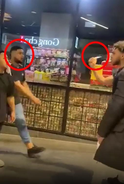 當時兩班人對罵,其中穿白色長褲的男子拿出小刀指嚇。(網上片段截圖)