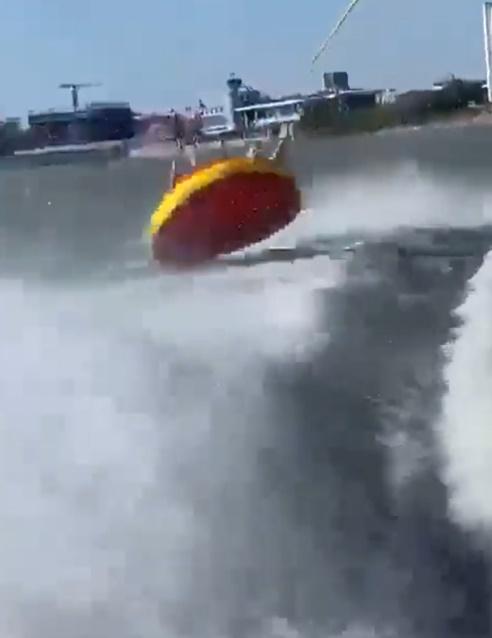 橡皮艇開始被高速拖曳後,在水面左搖右擺,2人間中被拋得腳底朝天。(Twitter)