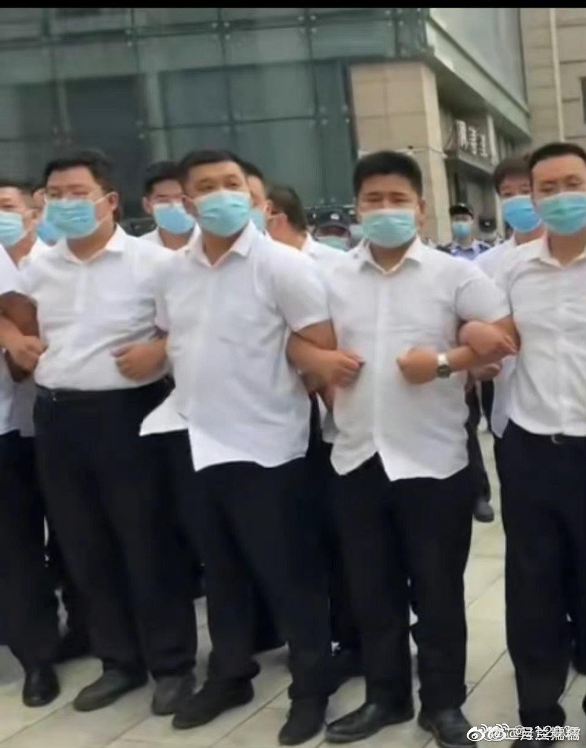 有身穿白衣的人士組成人鏈。(網上截圖)