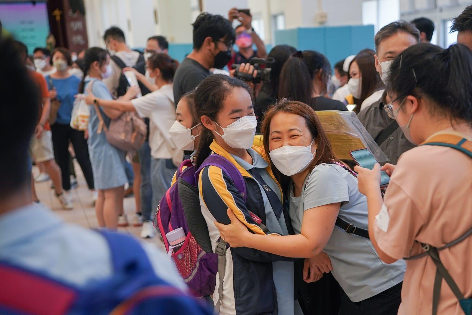 有學生與家長互相擁抱慶祝。(李睿哲攝)