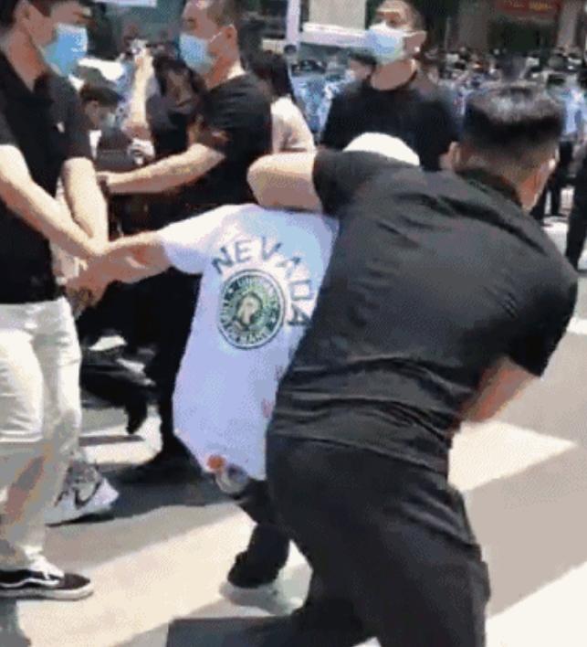 毆打河南問題村鎮銀行維權客戶的除了白衣人,還包括一批黑衣人,身穿制服的警察在外圍築成人牆,任由維權人士被黑、白衣人毆打、帶走。(互聯網)