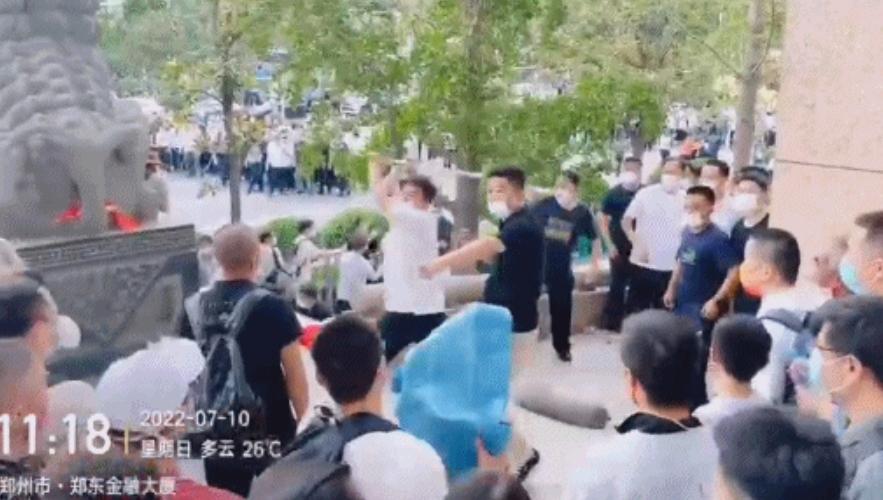 維權的河南問題村鎮銀行客戶遭大批白衣人拉扯毆打,而除了白衣人,打人者還包括一批黑衣人。(互聯網)
