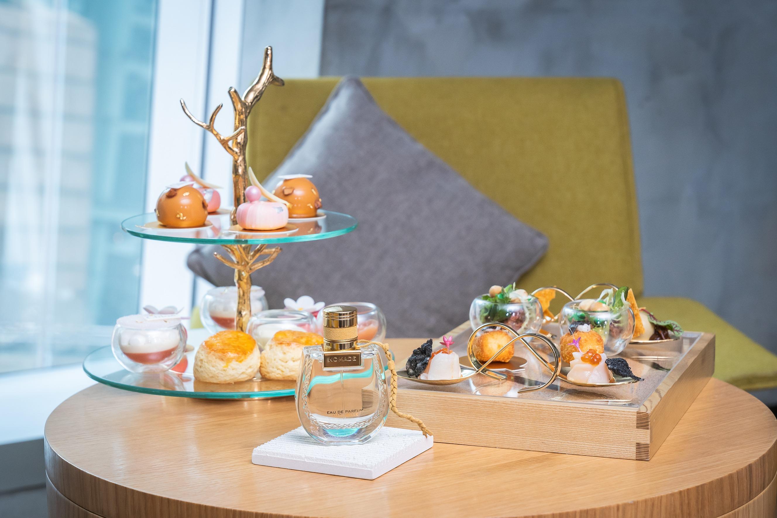 下午茶以大自然色調為主軸,鍍金樹枝裝飾串連的下午茶層架,及錶上「Nomade」字樣的木製餐盤盛載著精緻美饌。