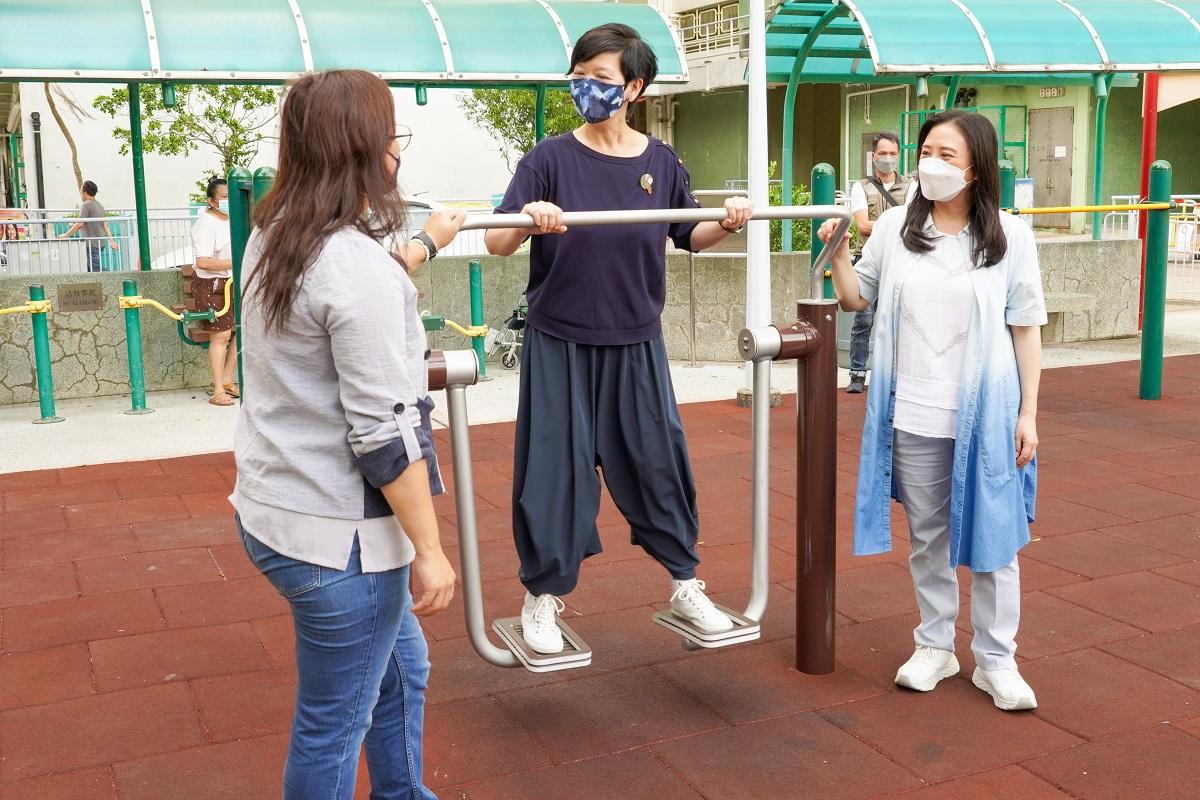 何永賢(中)探訪後,即場試玩美林邨公園的長者健體設施。(民建聯提供)
