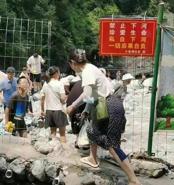 四川龍漕溝本為洩洪溝,但在網紅宣傳下成為消暑、野餐、玩水勝地,民眾無視警告字句,破壞鐵絲網入內。(互聯網)