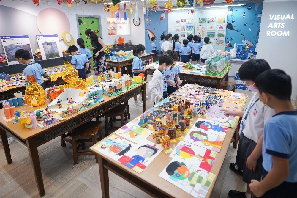 學生在視藝作品展中仔細欣賞同學的作品,並給予評分。