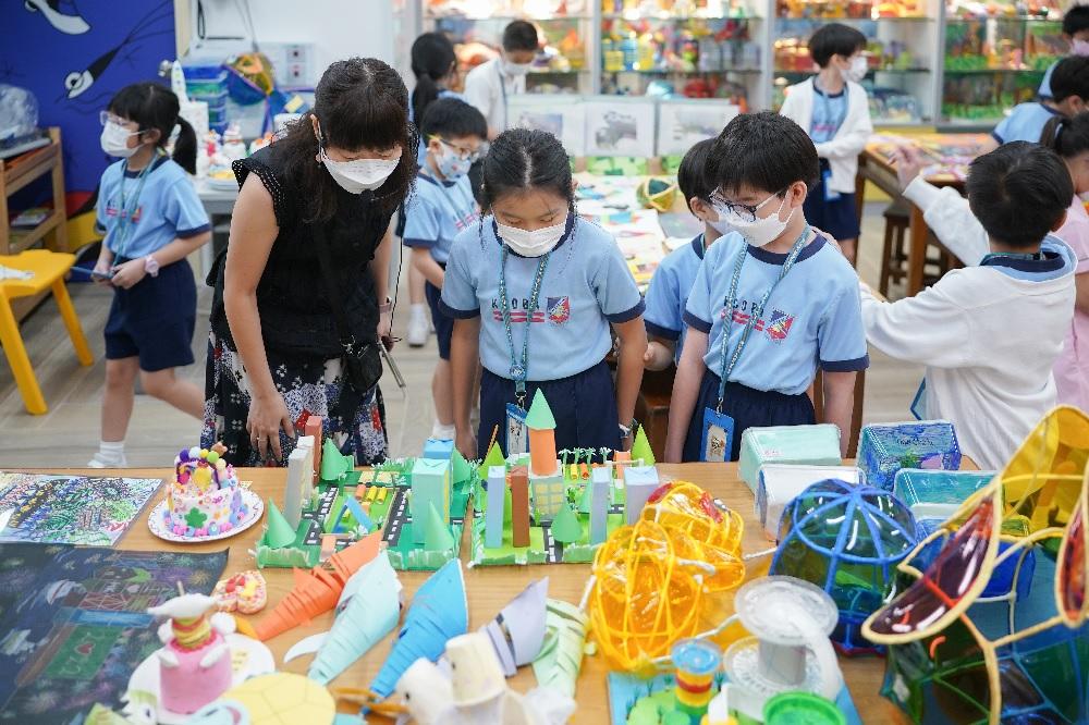 學生在視藝作品展中仔細欣賞同學的作品,並給予評分。