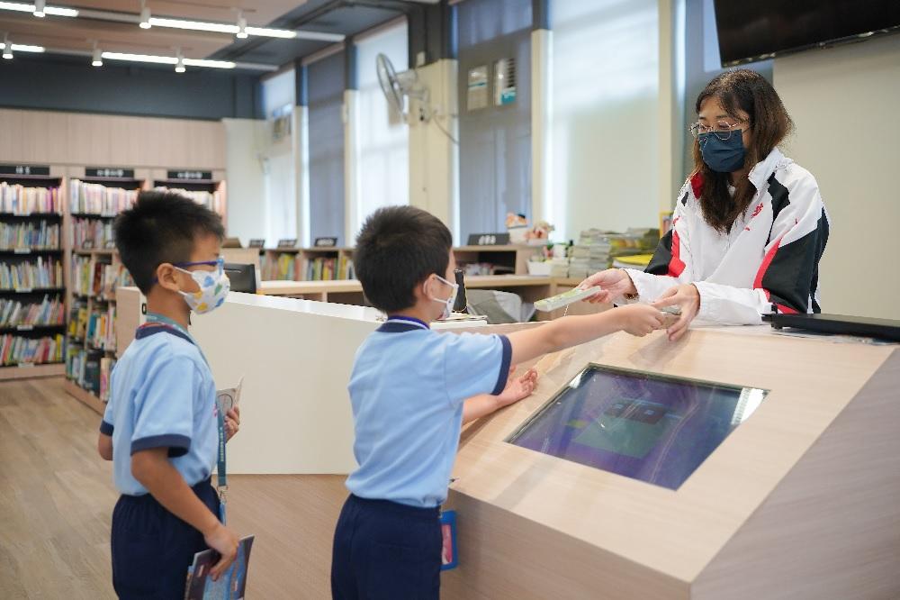 學生在圖書館借閱圖書,閱畢後,老師會為他們蓋上印章,存夠章印學生便可換取喜愛的禮物。