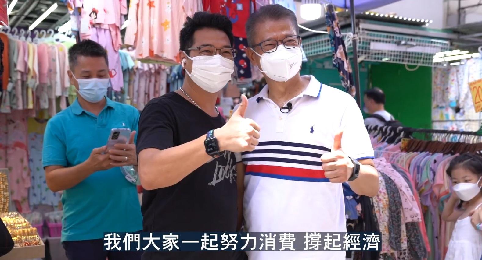 陳茂波在影片中落區搭巴士,並與市民及商戶合照。(陳茂波fb影片截圖)